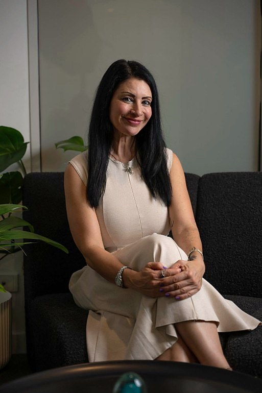 Janina, founder of Wonderfully AI, smiling as she sits on a sofa